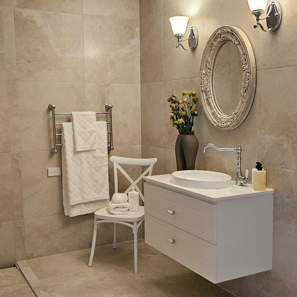 Elegant modern bathroom with wall-mounted vanity and marble-look tiles.